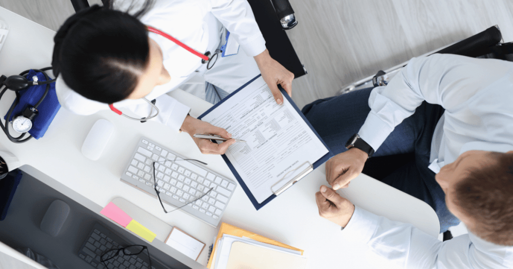 Two medical professional's looking at data on a clipboard