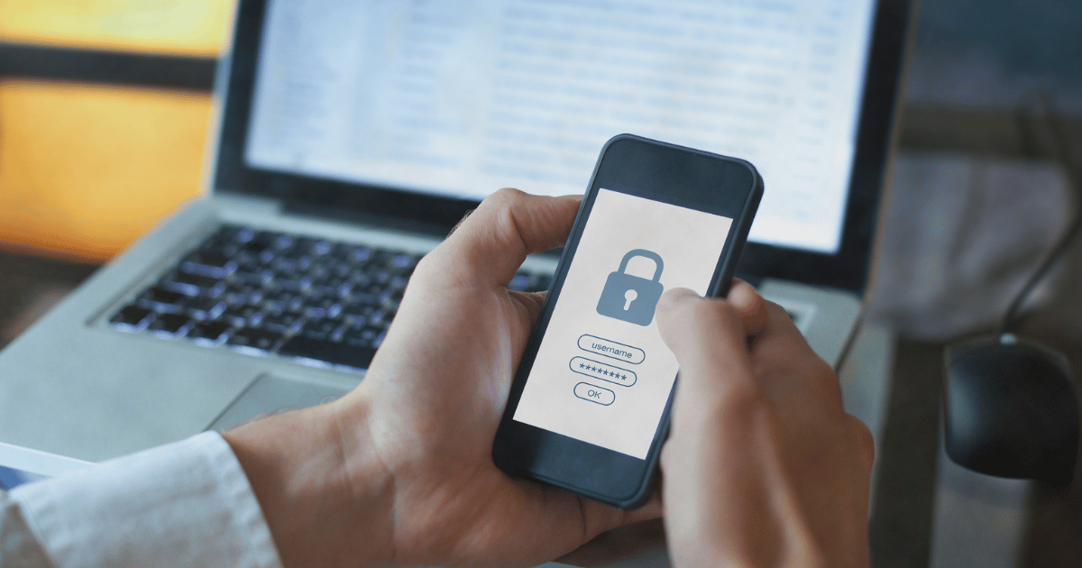 Person holding a phone with the screen displaying a prompt for a username and password